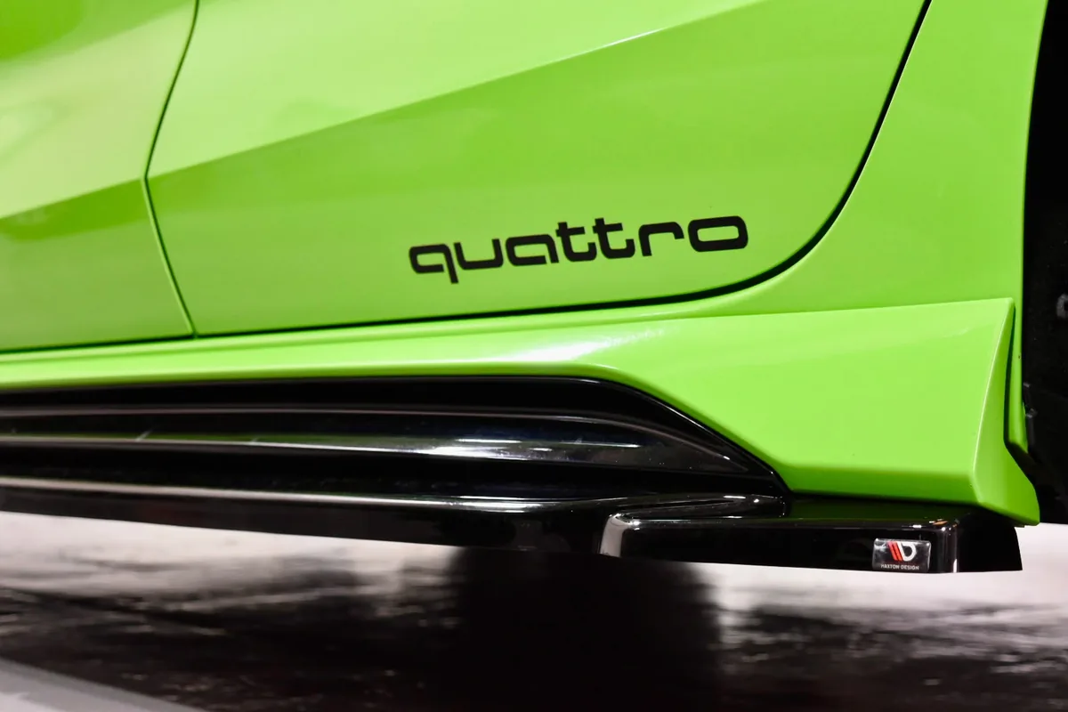 Close-up detail of the Quattro badge and sill trim on a Kyalami Green Audi RS3 at the East Midland Cars Leicester workshop